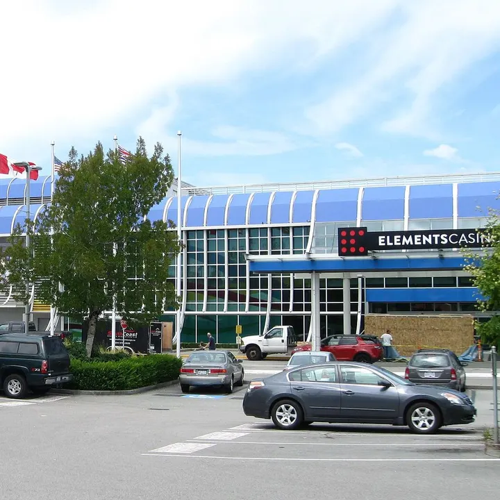 Elements Casino Surrey sur la 60 Avenue, avec son toit bleu incurvé et son enseigne de casino derrière le stationnement