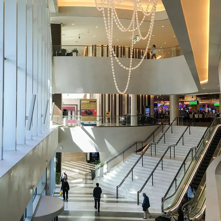 L'intérieur du Parq Vancouver : un haut atrium avec un lustre en chaînes et un escalier de marbre qui monte à la salle de jeu